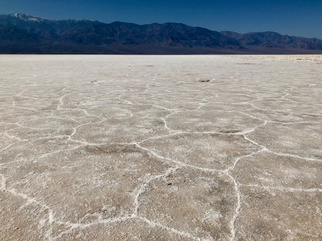 List of National Parks by State: A Complete List of All 400+ US National Parks 18 White salt basalts create hexagon shapes on the ground below mountains