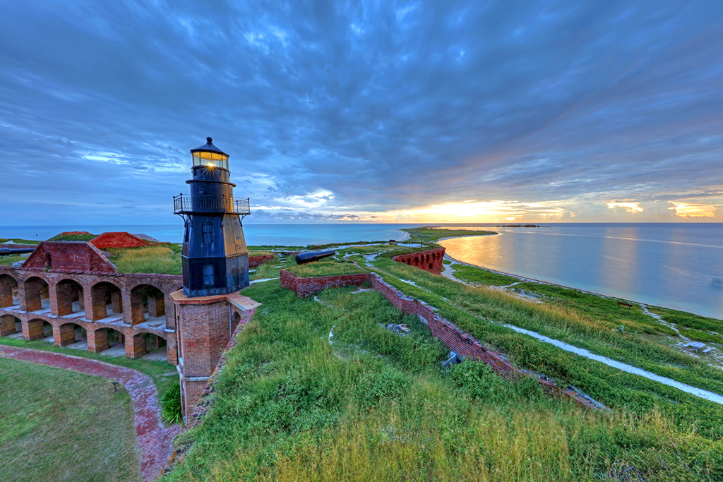Everglades National Park 16 A lighthouse on top of a brick fort with grass on the roof overlooking the ocean at sunset