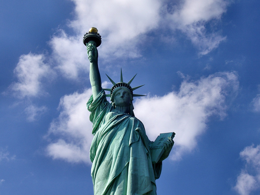 List of National Parks by State: A Complete List of All 400+ US National Parks 45 A green statue of a woman holding a book and a torch high above her head. She's wearing a crown.