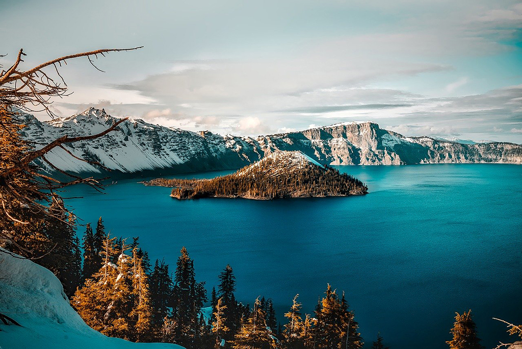 List of National Parks by State: A Complete List of All 400+ US National Parks 50 A small island in the middle of a crystal blue lake surrounded by mountains