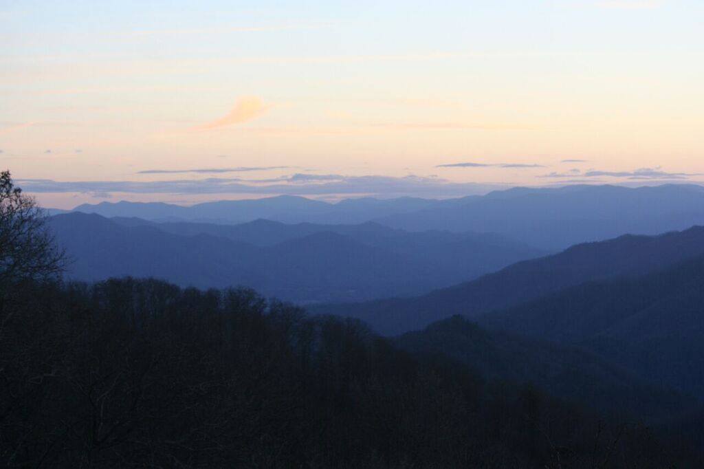 List of National Parks by State: A Complete List of All 400+ US National Parks 55 Sunset over a landscape of blue mountains