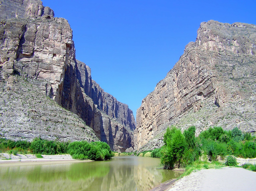 List of National Parks by State: A Complete List of All 400+ US National Parks 56 A river runs through a canyon with sand and trees at the bottom