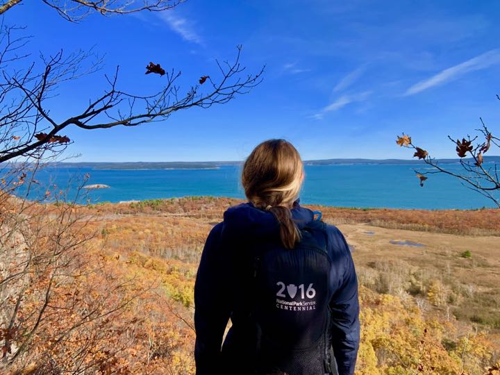 How to Hike the Heart-Stopping Precipice Trail in Acadia National Park 10 A woman takes in the view on a fall day in Acadia