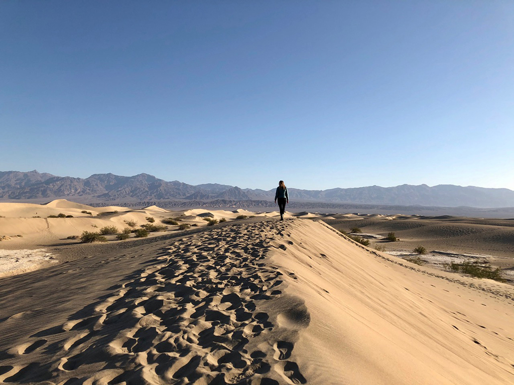A List of All 63 National Parks in the U.S. Ranked by Their Popularity 44 A woman walking on Sand Dunes in Death Valley, one of the US national parks