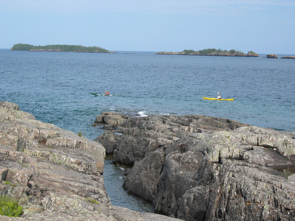 A List of All 63 National Parks in the U.S. Ranked by Their Popularity 80 Two kayakers in the ocean next to a group of rocks in Isle Royale, one of the US national parks