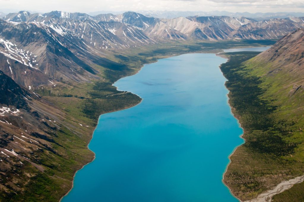 16 Astonishing National Parks in Alaska 16 A turquoise lake below mountains in Lake Clark, one of the national parks in Alaska