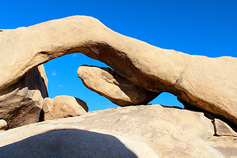 The 20 Best Hikes in Joshua Tree National Park That Will Blow Your Mind 22 Arch Rock stretches across its base below blue sky. Arch Rock is one of the best hikes in Joshua Tree.