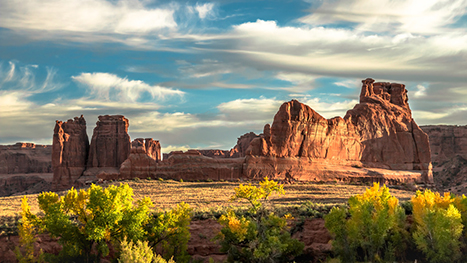 10 Best Hikes in Arches National Park That Lead to the Greatest Natural Arches in Utah 8 Sun shines on the valley below large red rock formations. Park Avenue is one of the best hikes in Arches National Park