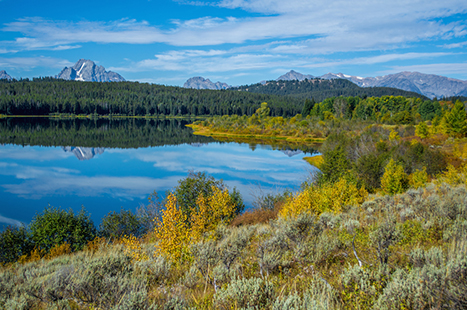 Best Hikes in Grand Teton: The 14 Best Long Day Hikes and Multi-Day Hikes in Grand Teton National Park 33 A blue lake with mountains and sky reflected in its waters. Two Ocean is one of the best hikes in Grand Teton National Park.