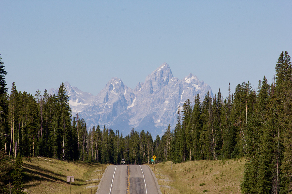 Best Hikes in Grand Teton: The 14 Best Long Day Hikes and Multi-Day Hikes in Grand Teton National Park 2 A road leads to mountains partially obscured by smog
