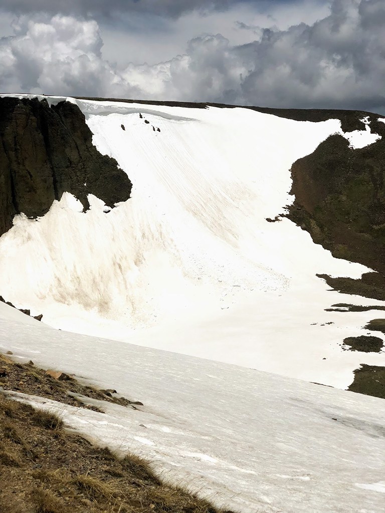 Driving Trail Ridge Road in Rocky Mountain National Park: Everywhere You Should Stop on The Exhilarating Drive 10 A large expanse of white ice and snow falls down a mountainside, seen while driving Trail Ridge Road
