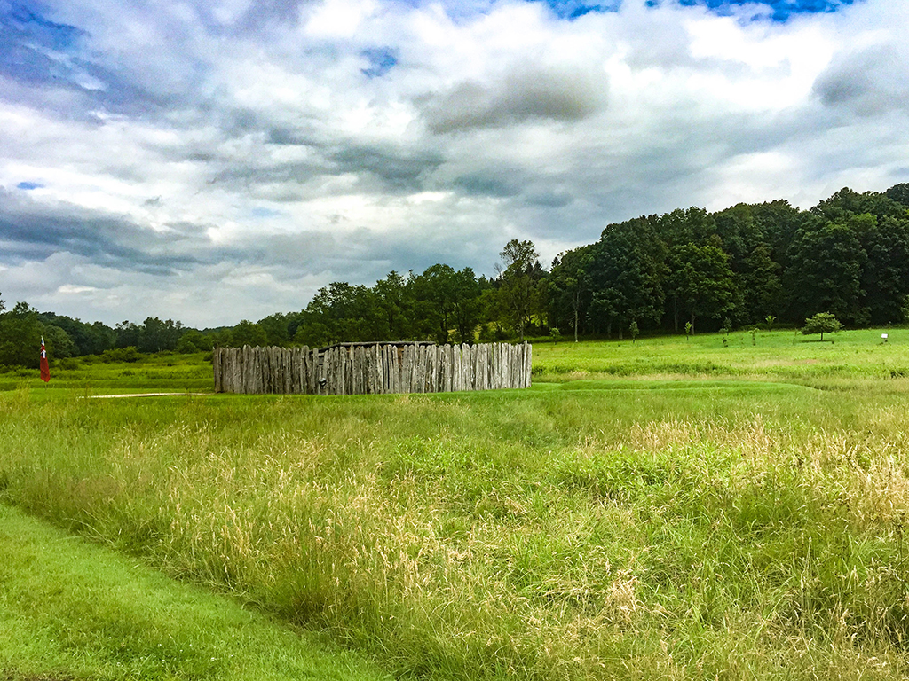 Follow the Footsteps of Alexander Hamilton in America's National Parks 11 Wooden fence in the middle of green grass at Fort Necessity National Battlefield