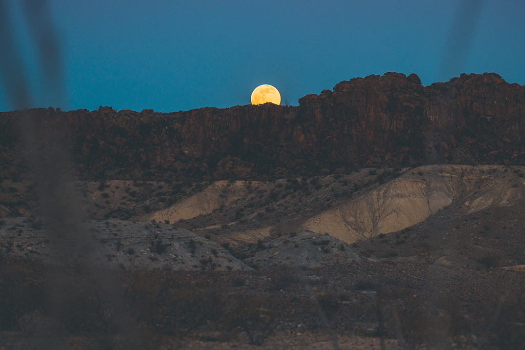 How to Spend 3 Days in Big Bend National Park: Itinerary 1 The glowing moon rises over mountains while spending 3 days in Big Bend National Park