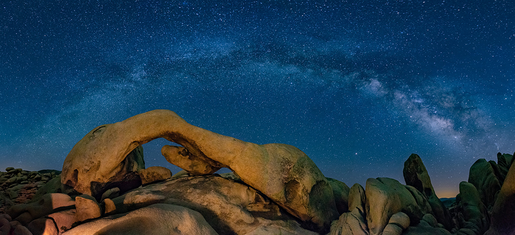 Camping in Joshua Tree National Park: The Ultimate Guide to All 9 Campgrounds 1 A natural rock arch below the milky way, seen camping in Joshua Tree National Park