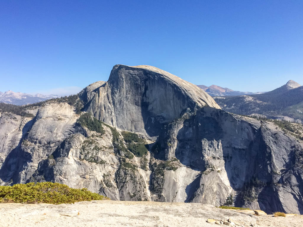8 of the Best Hikes in Yosemite National Park for Breathtaking Views 27 A dome-shaped granite rock towers over trees in Yosemite National Park