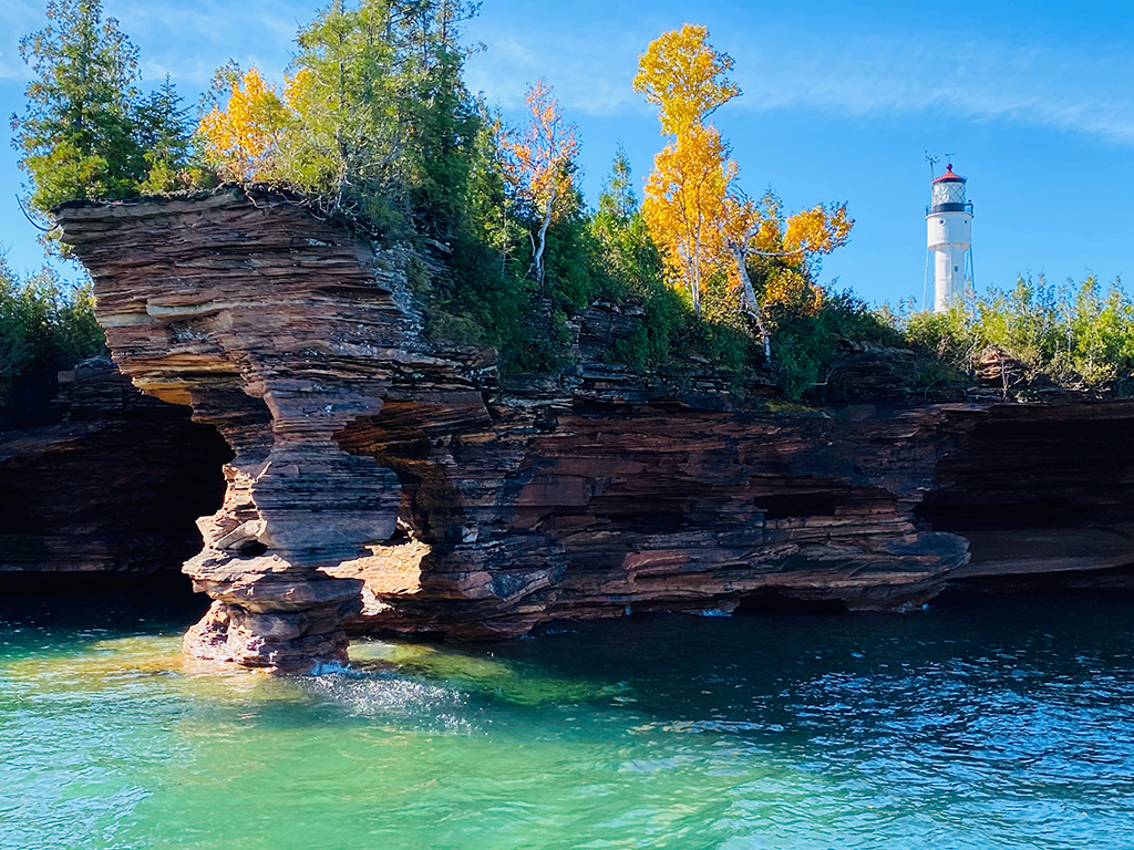 List of US National Parks in Alphabetical Order (All 400+!) 18 A lighthouse above a rock near teal water