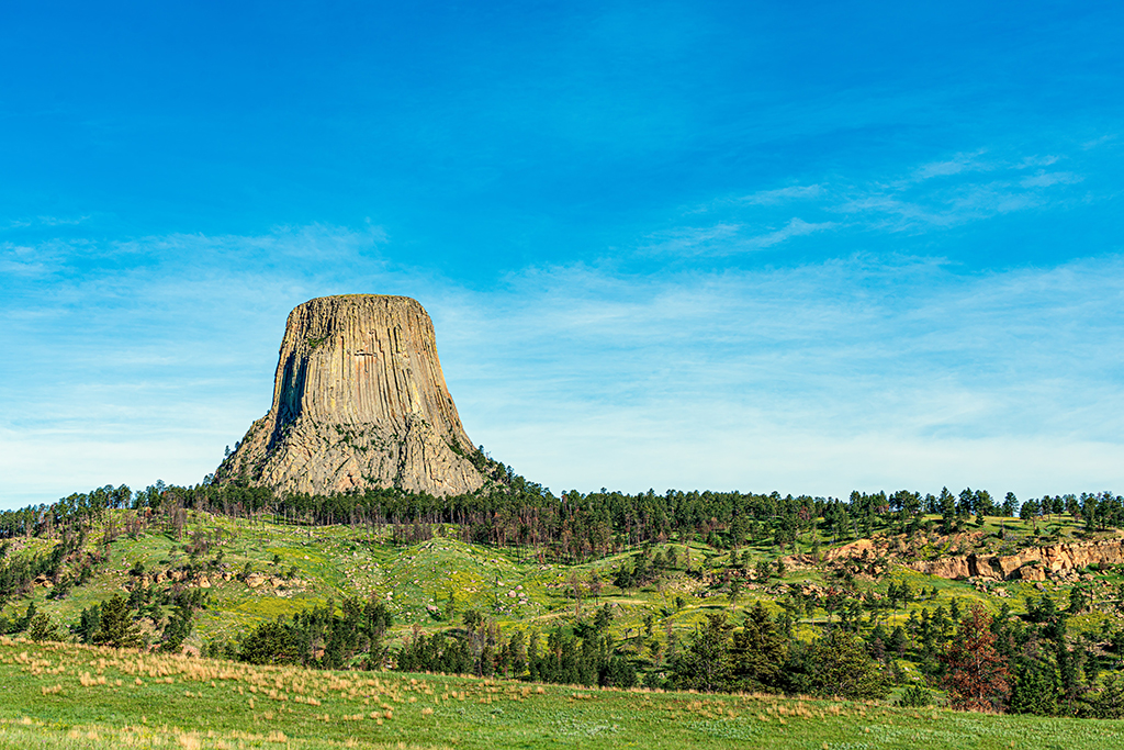 List of US National Parks in Alphabetical Order (All 400+!) 21 A rock tower shoots toward the sky surrounded by green prairie