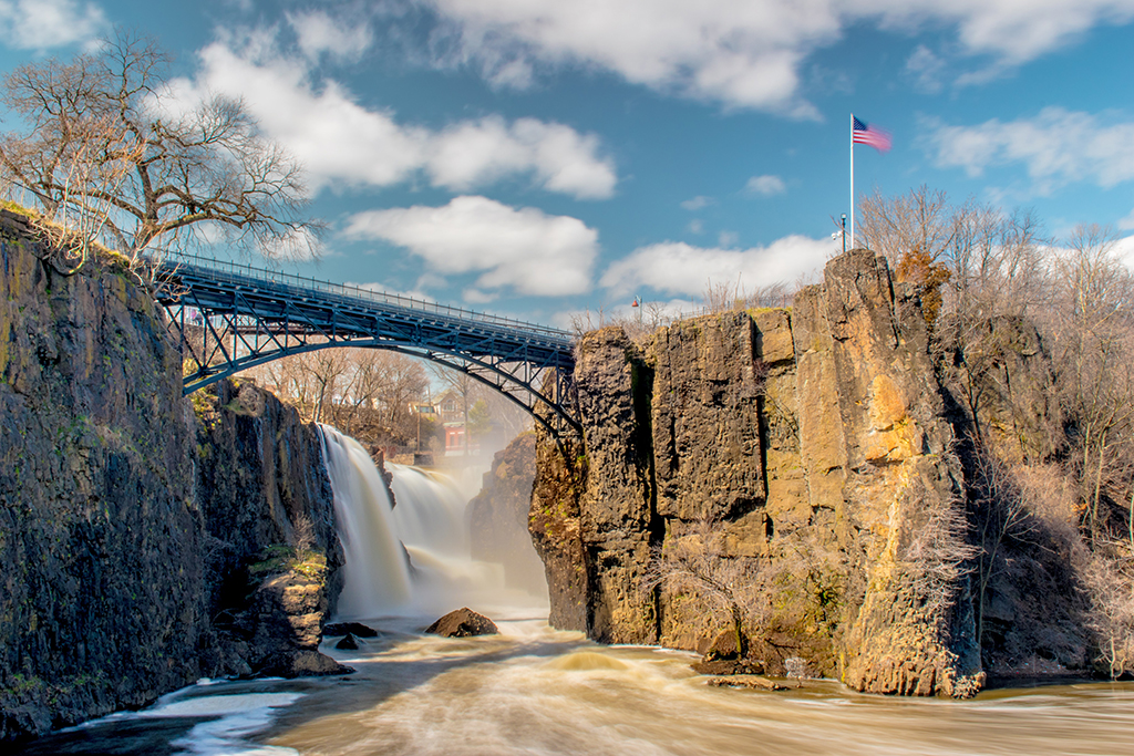 List of US National Parks in Alphabetical Order (All 400+!) 33 A waterfall below a black steel bridge