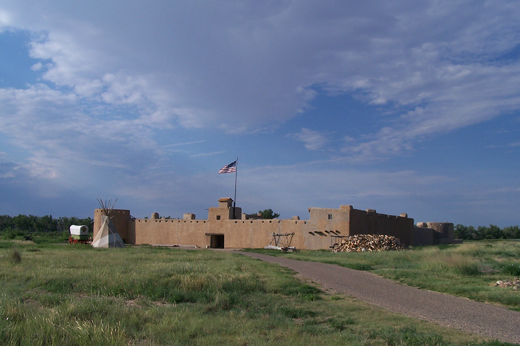 12 Breathtaking National Parks in Colorado 4 A reconstructed fort sits on green grass. There is a trail leading to it. Bent's Old Fort is one of the national parks in Colorado.
