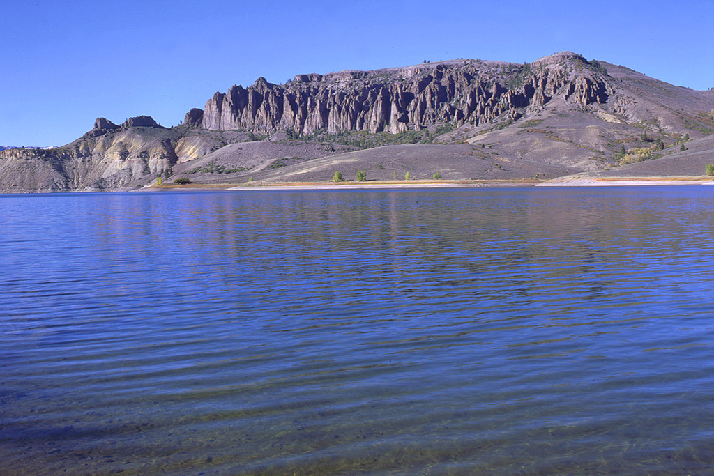 12 Breathtaking National Parks in Colorado 13 Gray mountains rise above a deep blue lake.