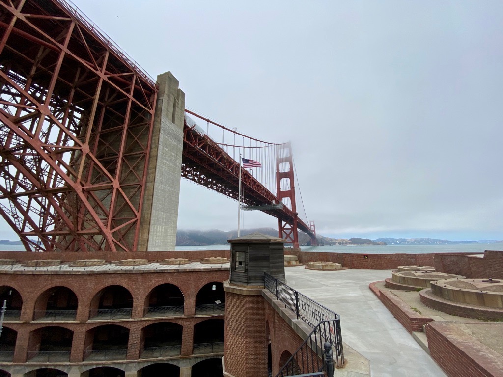 11 Incredible National Parks Near San Francisco 4 A red brick fort below a red suspension bridge covered in fog
