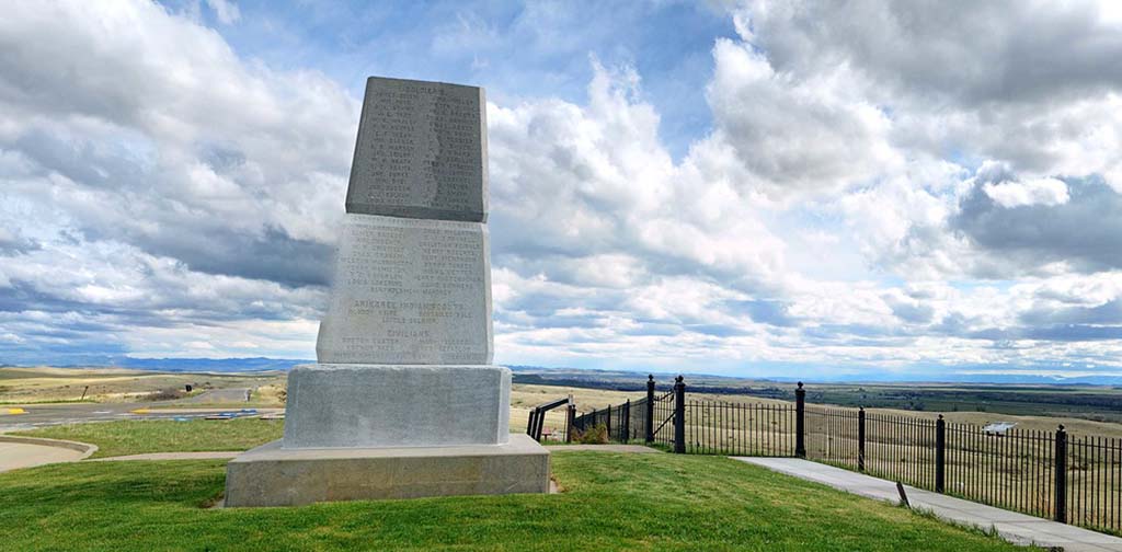 8 Marvelous National Parks in Montana 26 A large monument with names engraved stands on a grassy hill