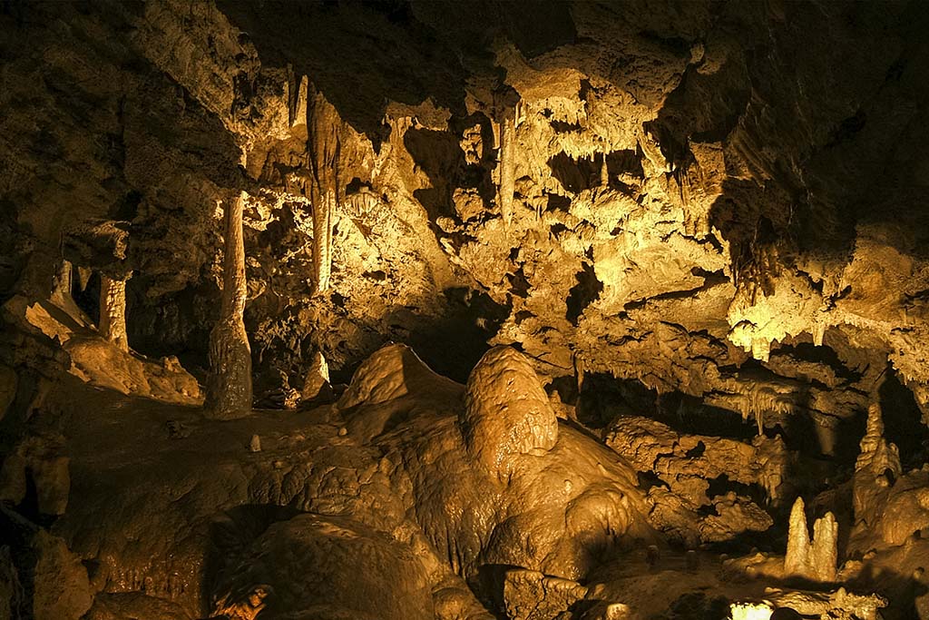 5 Incredible National Parks in Oregon 22 The second largest room in Oregon Caves, one of the oregon national parks, in dim yellow light