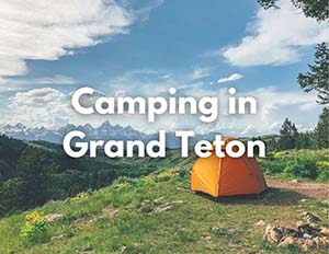 Grand Teton National Park 3 An image of an orange tent on green grass overlooking a scenic mountain vista. The image has centered text that reads "Camping in Grand Teton" in white letters
