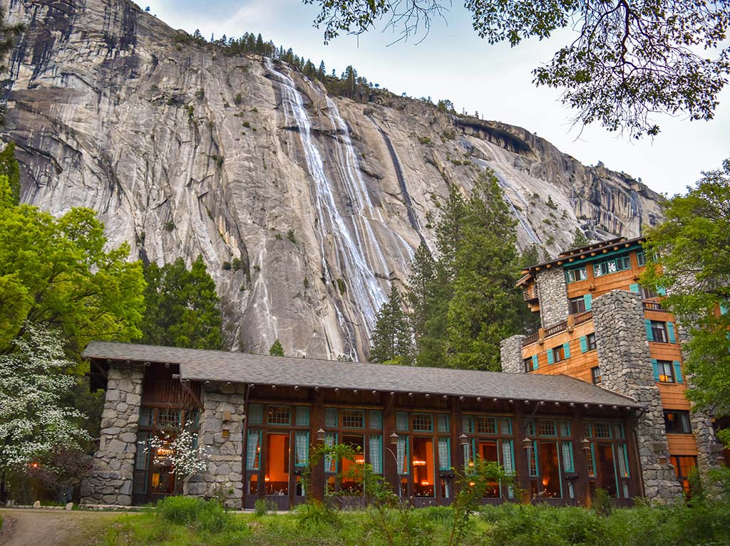 Yosemite Itinerary: 5 Ideas for Day-to-Day Experiences in an Iconic National Park 8 The historic Ahwahnee Hotel beneath granite slopes with a small waterfall