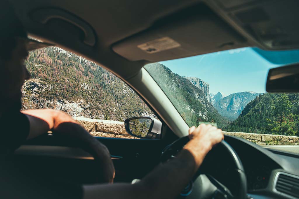 Yosemite Itinerary: 5 Ideas for Day-to-Day Experiences in an Iconic National Park 4 A man drives a car near a scenic view point seen through the front window