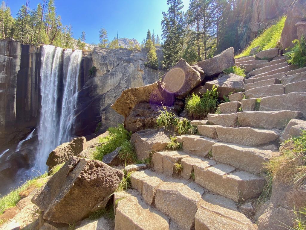 Yosemite Itinerary: 5 Ideas for Day-to-Day Experiences in an Iconic National Park 37 A granite staircase passes a white waterfall known as Vernal Falls on the Mist Trail in Yosemite, a quintessential hike on any Yosemite itinerary