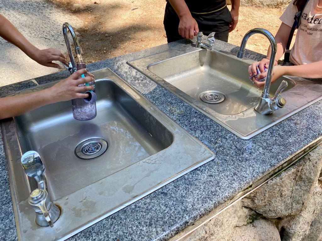 Hiking the Yosemite Mist Trail: Is It Worth the Climb? 7 Visitors fill their water bottles and wash their hands at a large water station at Vernal Falls in Yosemite
