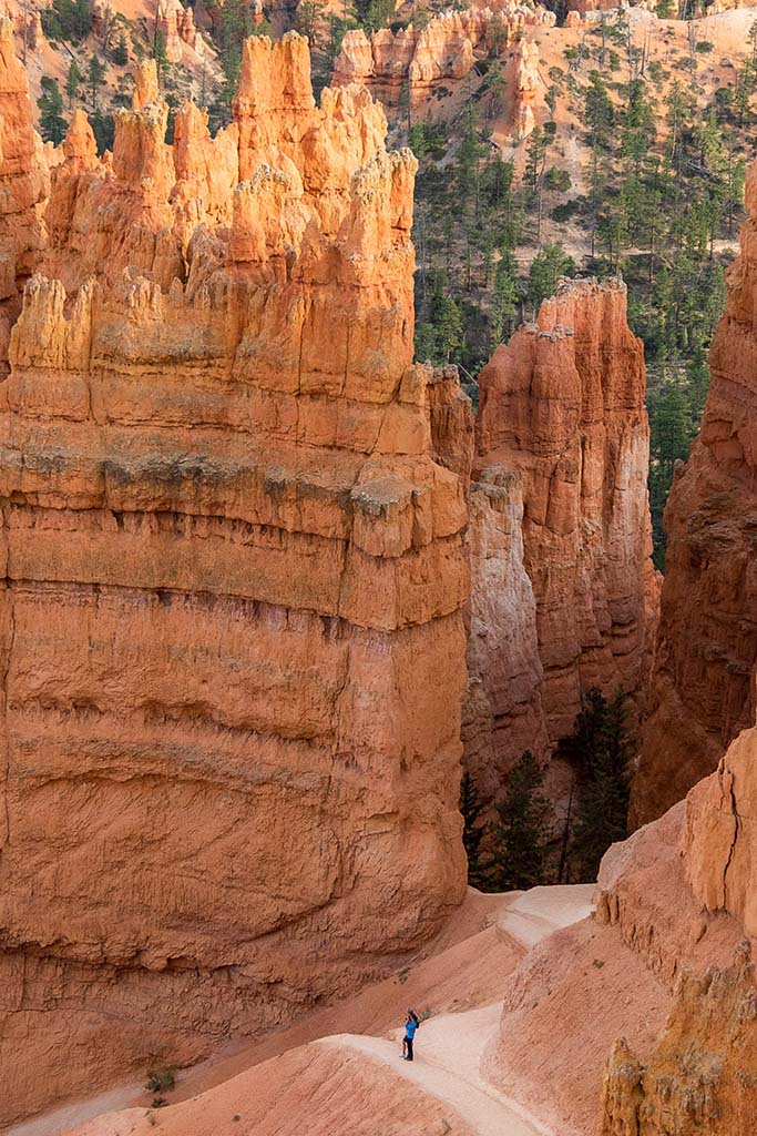 12 Beautiful Hikes in Bryce Canyon National Park 7 A lone hiker on a trail surrounded by orange rock formations