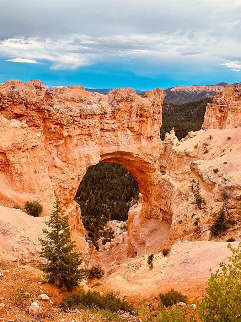 12 Beautiful Hikes in Bryce Canyon National Park 25 A natural orange rock bridge below blue skies