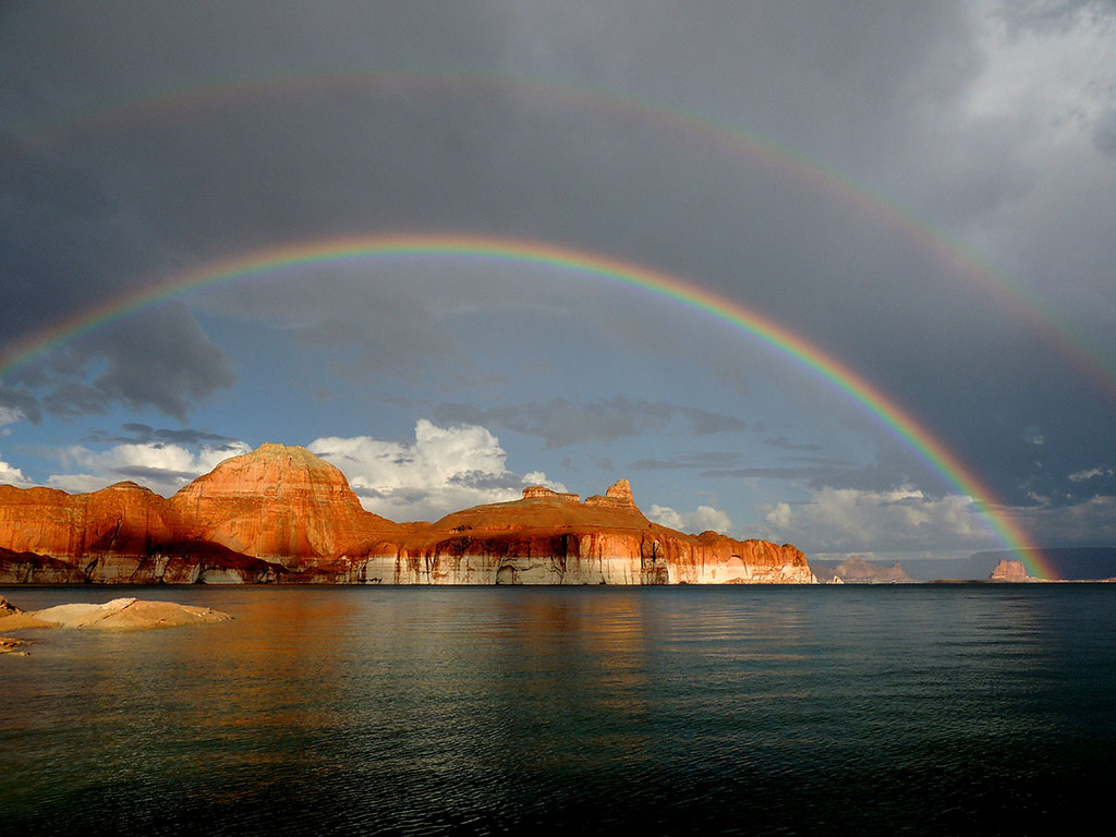 22 Amazing National Parks in Arizona 8 A rainbow arcs over red rocks and a blue lake