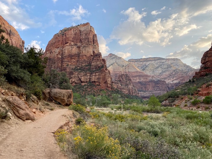 Perilous But Worth It: How to Safely Conquer the Angels Landing Hike in Zion National Park 30 A sandy trail leads to a large rock formation, known as Angels Landing, above a river