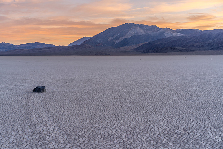 2 Day Death Valley Itinerary: How to See the Best of the West in 2 Days 43 A rock with a small track behind it on the desert floor with mountains in the background