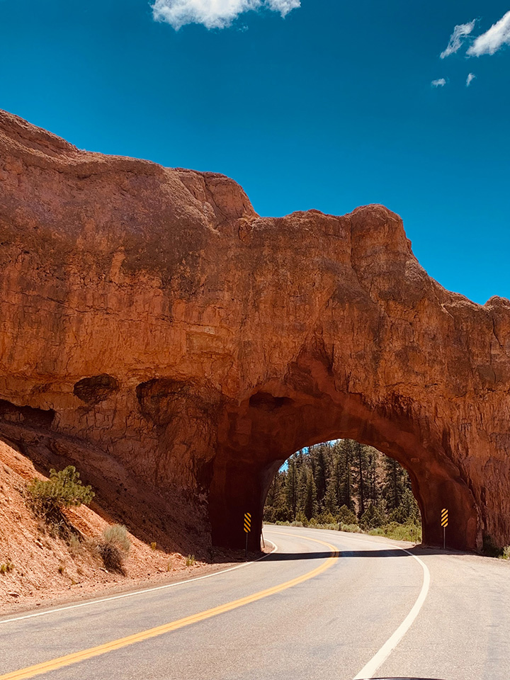 20 Fun Things to Do in Bryce Canyon National Park 5 A road travels under a red rock formation