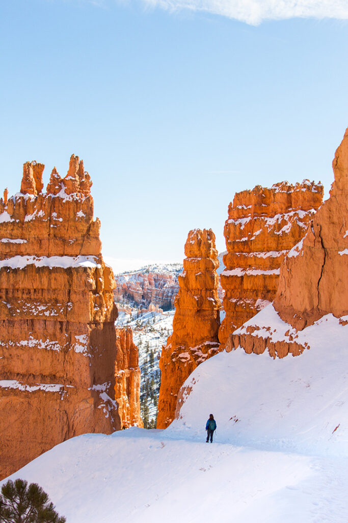 20 Fun Things to Do in Bryce Canyon National Park 23 A hiker traverses a trail in Bryce Canyon that is covered in snow, one of the best things to do in Bryce Canyon National Park
