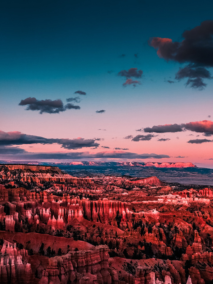 20 Fun Things to Do in Bryce Canyon National Park 19 The setting sun casts purple and pink hues across the sky over an amphitheater filled with hoodoos