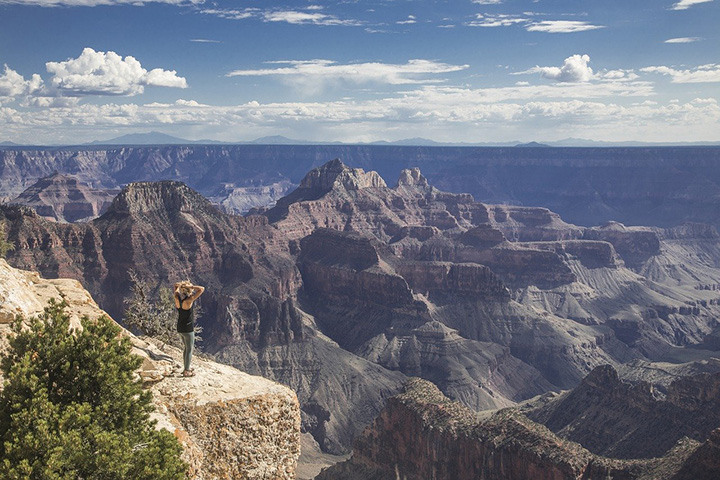 13 Inspiring Things to Do in Grand Canyon National Park 13 A woman stands near the edge of the rim of the Grand Canyon. Hiking is one of the best things to do in Grand Canyon National Park.