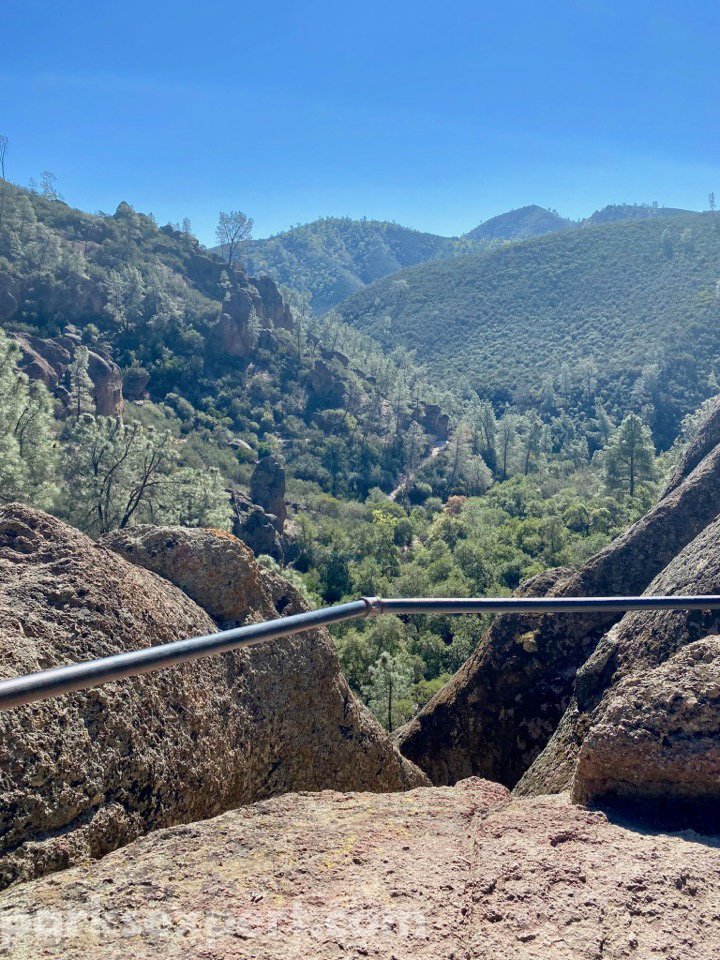 14 Phenomenal Things to Do in Pinnacles National Park 18 A railing provides a safe overlook of green covered hills