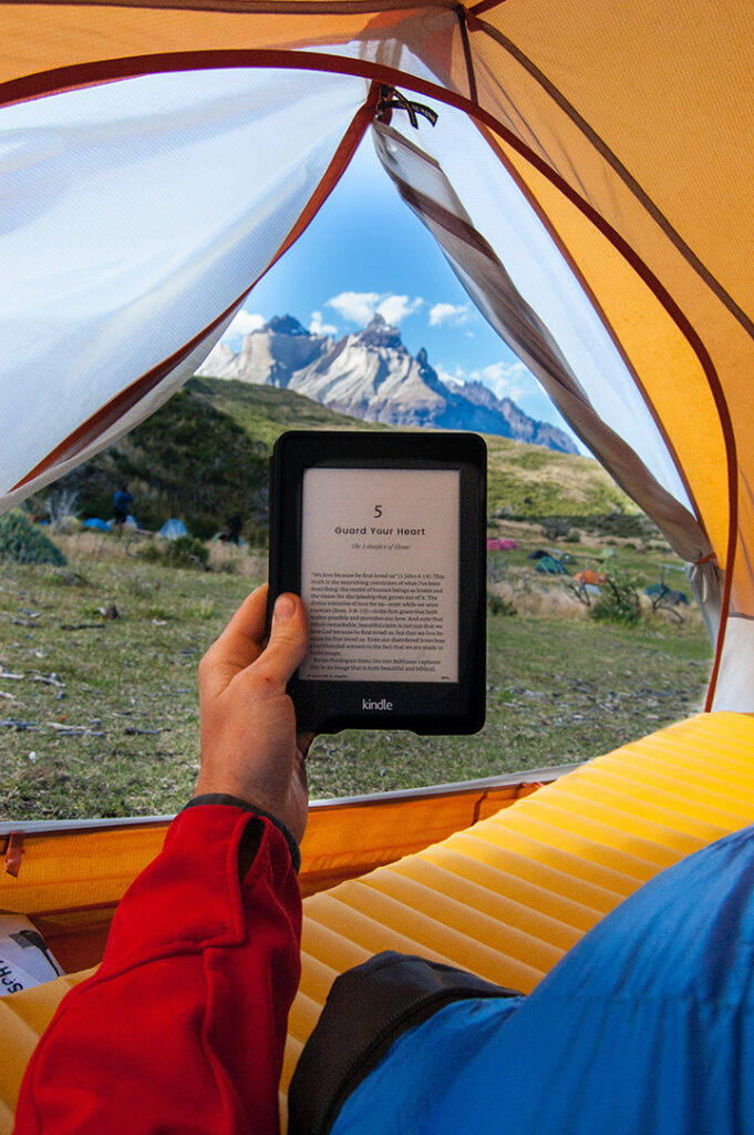 The 31 Best National Park Books for Every Reader 22 A camper reading national park books on his ereader