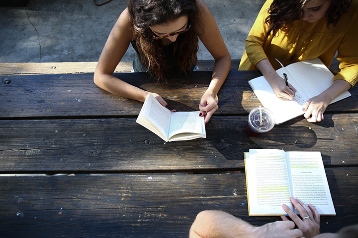 The 31 Best National Park Books for Every Reader 30 Three people sit at a table to write