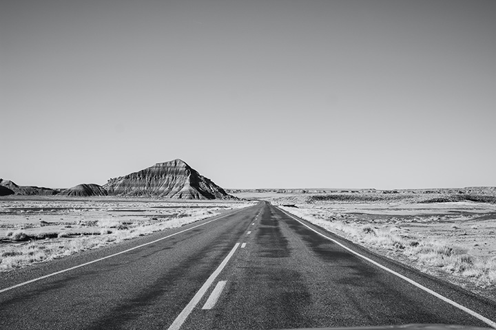 How to Spend One Day in Petrified Forest National Park Itinerary 3 A black and white photo of a scenic paved road in the desert seen while spending one day in Petrified Forest National Park