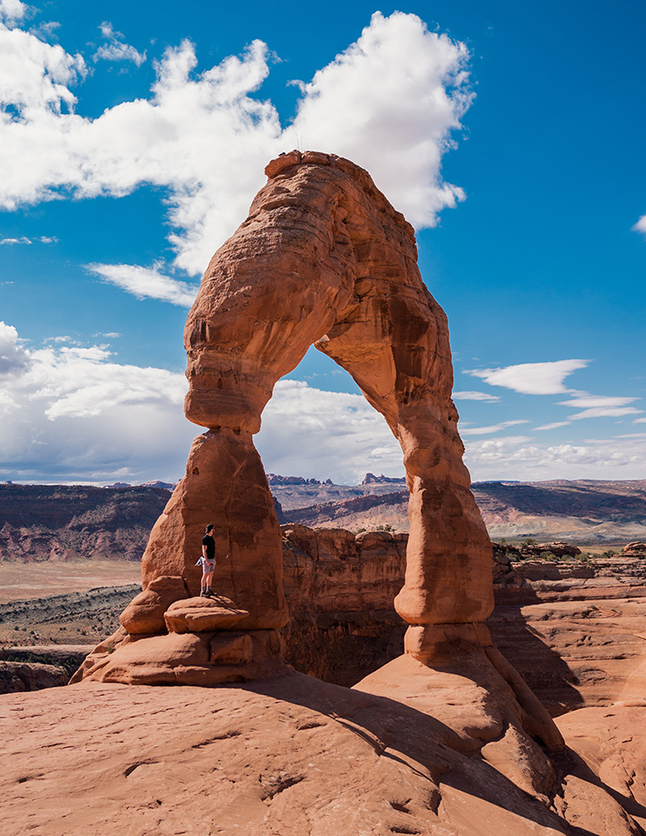 Ultimate Guide to an Epic One Day in Arches National Park Itinerary 19 A hiker stands on a rock at the base of Delicate Arch
