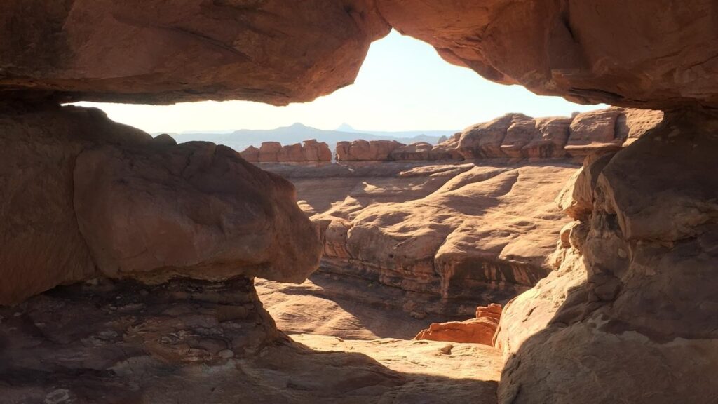 The 15 Best Hikes in Canyonlands National Park: A Comprehensive Guide 51 A canyon seen through the hole in the wall of another canyon
