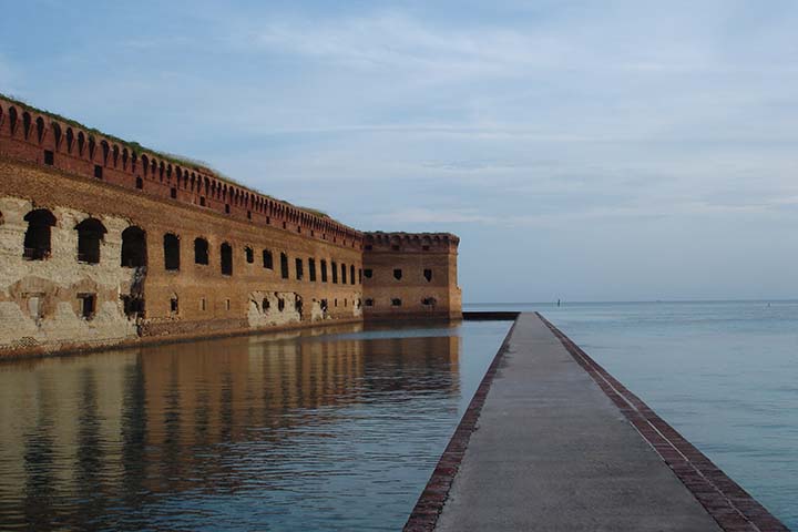 The Absolute Best Time to Visit Dry Tortugas National Park 1 A brick and concrete moat surrounds a brick fort in the ocean
