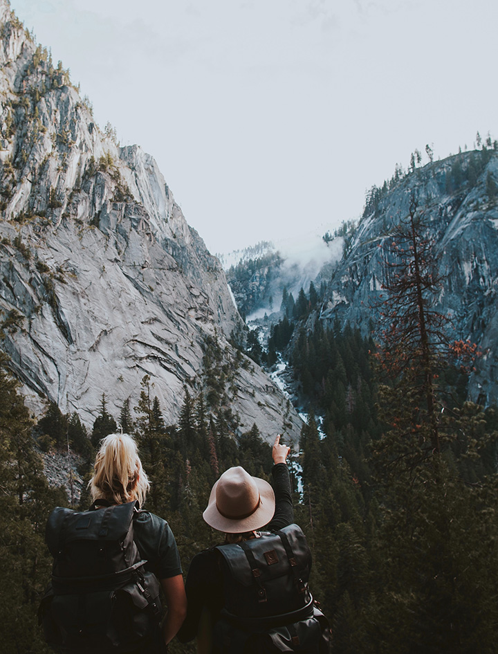 Two hikers point at scenic landmarks