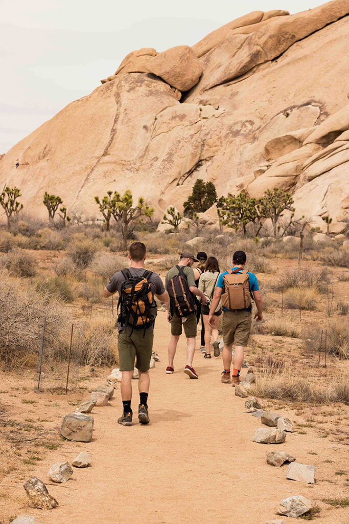 11 Hiking Safety Tips for Your Next Trail Adventure 15 A group of hikers walks on a trail through the desert